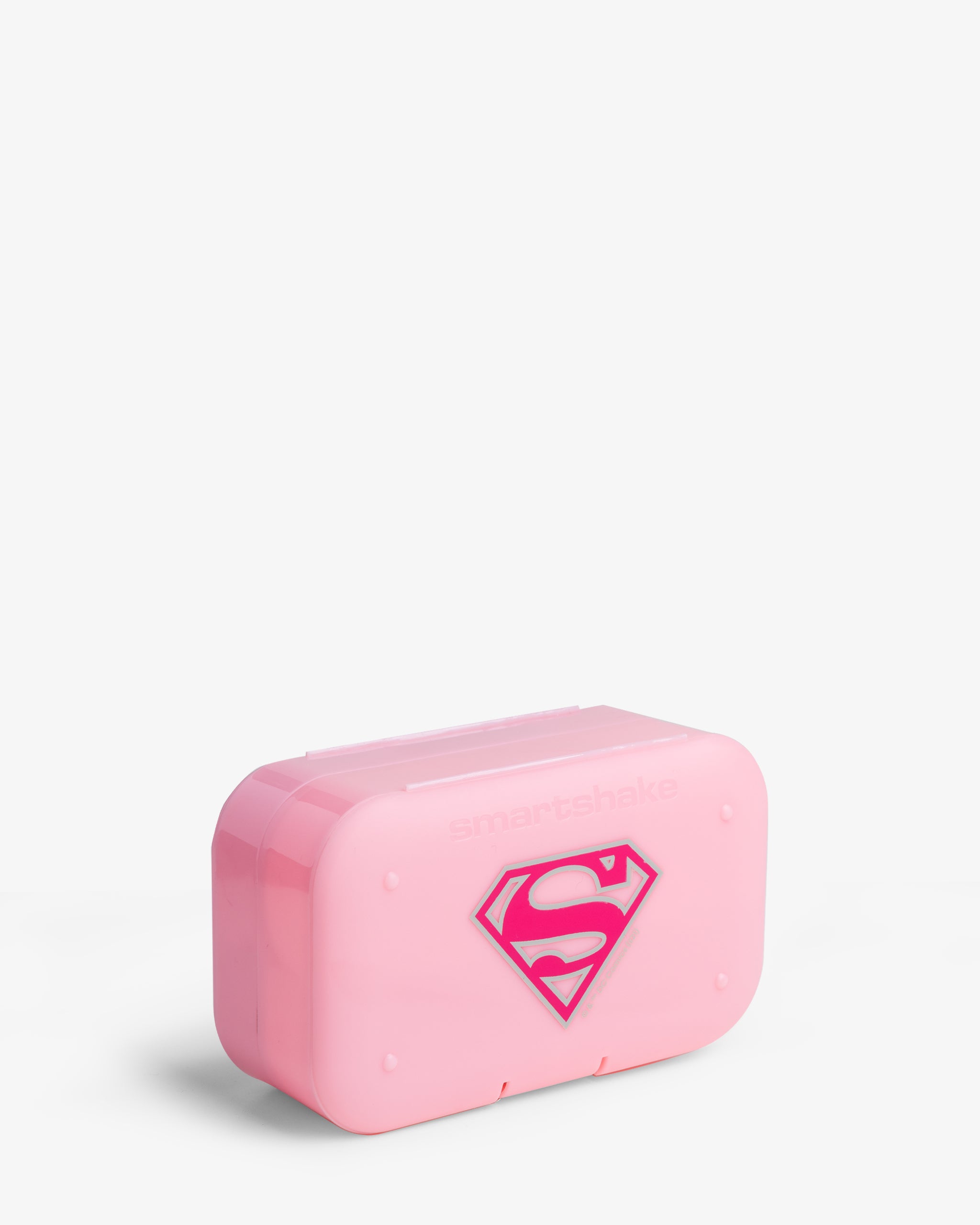 A pink pill box organizer with the Supergirl logo on the front.